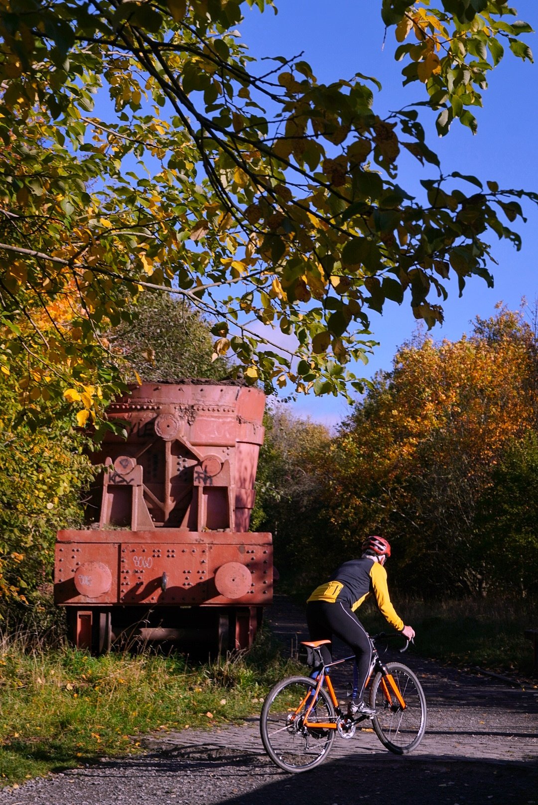 Cyclist passing a smelt wagon on an autumn trail, Lydgetts Junction