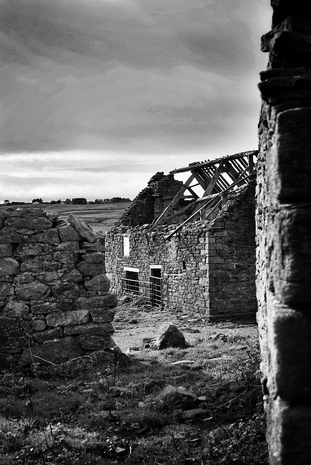 Roofless stone barn under a dramatic sky